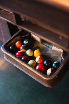 Vintage billiard table with pool balls in tray  

