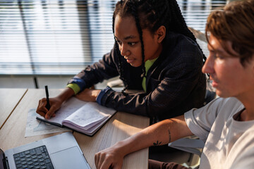Diverse colleagues discussing over laptop in office