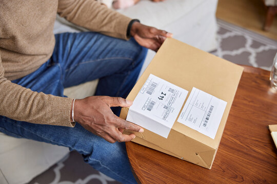 Man opening package on table at home