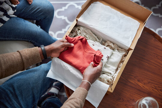 Opening box of new clothes for baby