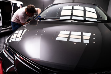 taller de pintura, trabajador aplicando cinta de enmascarar en automovil