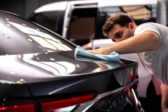 car detailing frotando pa&ntilde;o de microfibra con cera el automovil 