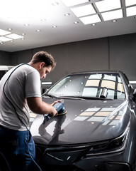 Hombre puliendo pintura de automovil con pulidora y pasta de pulir para dar brillo