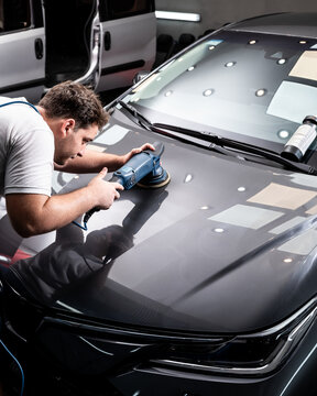 Hombre puliendo pintura de automovil con pulidora y pasta de pulir para dar brillo
