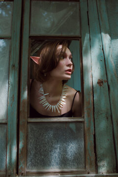 Portrait of an Elf girl throw the dirty window