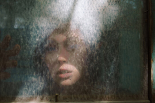 Portrait of an Elf girl throw the dirty window