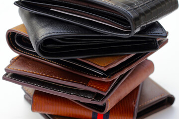 Stack of black and brown wallets on white background.