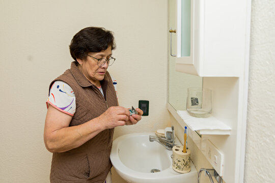Elderly woman flossing her teeth during an oral cleaning routine