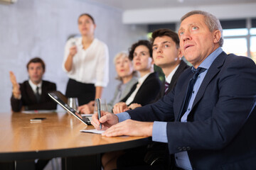 Group of businessmen attentively watching a presentation in a meeting room
