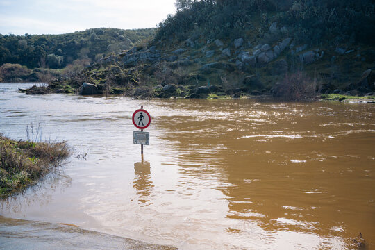 Flooded road with submerged pedestrian sign