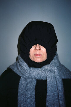 Anonymous woman wearing a hood and scarf hiding her face