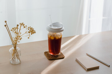 Iced tea with notepad and pencil on a desk with natural light