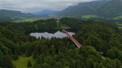 Aerial view of Heini-Klopfer-Skiflugschanze near Freibergsee in Oberstdorf, Bavaria, Germany. Iconic ski flying hill with observation deck, surrounded by stunning Bavarian Alps and lush summer scenery