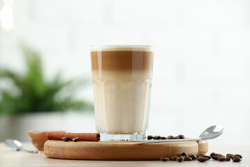 Tasty latte macchiato in glass on wooden table, closeup