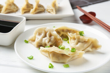 Delicious gyoza dumplings with chives served on white table, closeup