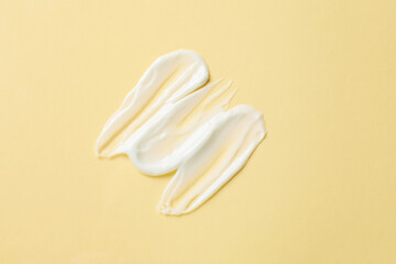 Sample of body cream on beige background, top view