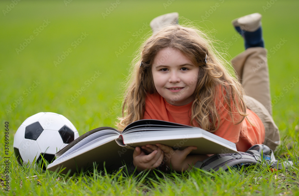 Poster child reading a book in the grass. child enjoying a book story outdoors. child studying with book in
