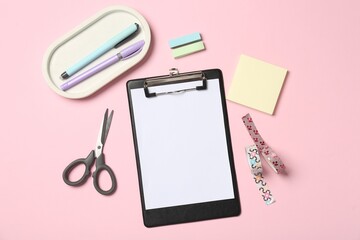 Flat lay composition with clipboard and blank paper on pink background. Space for text
