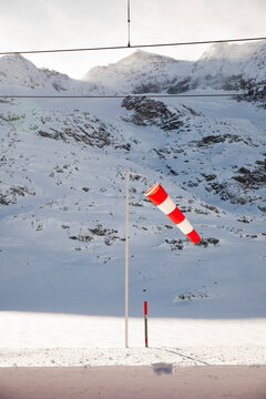 Red and white windsock in a snowy mountain setting