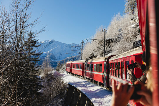 Train passengers capturing scenic snowy landscape