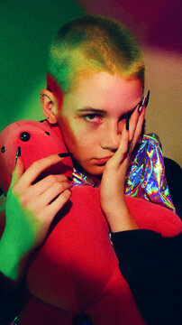 Androgynous Person with Green Buzzcut Poses with Pink Teddy Bear