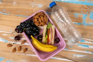 School lunch presentation. Top view showing lunch box filled with nutritious foods, protein, fruit and grains