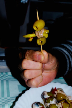 man with a spanish banderilla, a skewer with pickles