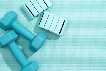 Blue Dumbbells and Wrist Weights on Yoga Mat