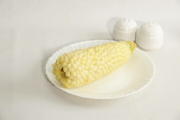 white boiled corn with chesse on the kitchen table
