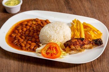 grill roasted chichen serve with rice an pinto beans french fries and salad 