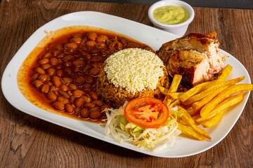 grill roasted chichen serve with rice an pinto beans french fries and salad 