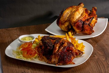 grilled roast chicken served with noodles and frias an lettuce salad antomato in white plate