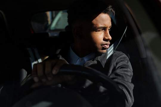 young driver using  in the car in sunlight in the city