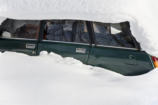 Car buried in snow in a winter 