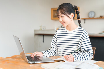 家でパソコンを使いながら勉強する小学生,中学生の女の子,子供
