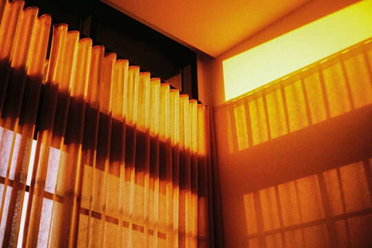 Film photo of a beautiful sunlight casting shadows on curtains