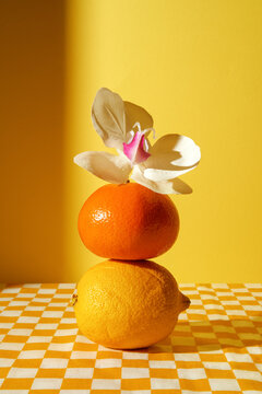 Naklejki Lemon, orange and flower on checkered tablecloth. Natural still life