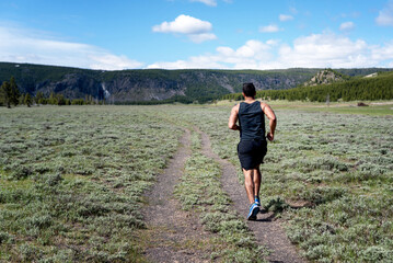 Man jogging in Yellowstone National Park on a bright summer day