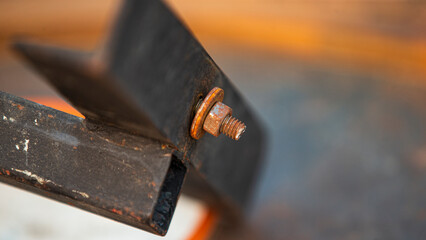 Old rusty bolt and nut on a piece of iron, close-up