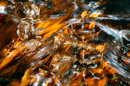 Reflection of golden chalice on shimmering surface