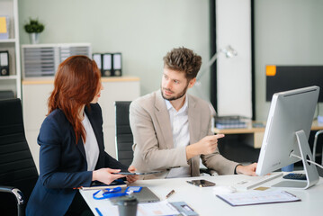 Two business workers talking on the smartphone and using laptop at office.