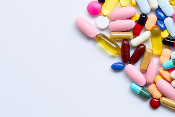 Colorful tablets with capsules and pills on white.