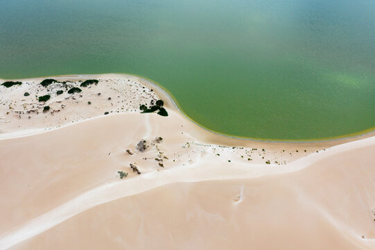Sand dunes on the eadge of a green lagoon