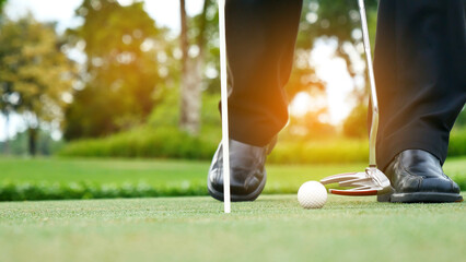 Businessman playing Golf ball practice hit swing on tee in golf club outdoor green field with...