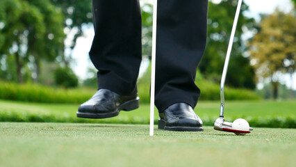 Businessman playing Golf ball practice hit swing on tee in golf club outdoor green field with...