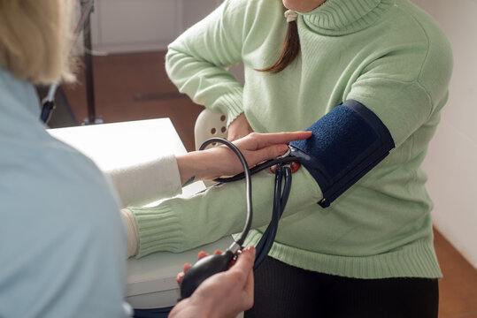 Doctor measures the patient's blood pressure