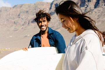 Surf-loving friends converse while making their way to the beach