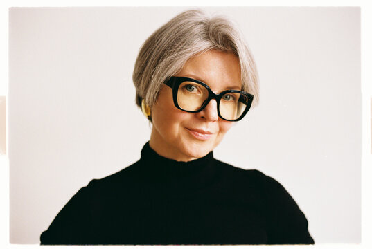 Stylish older woman with short gray hair and oversized glasses