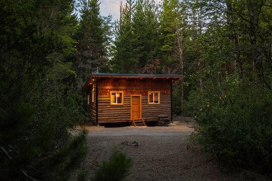 Cozy Wooden Cabin in Serene Forest Setting at Dusk
