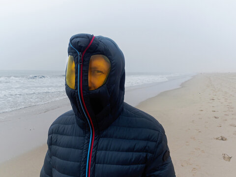 Hooded guy on the beach in foggy weather